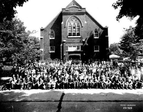 Large group in front of a brick church.